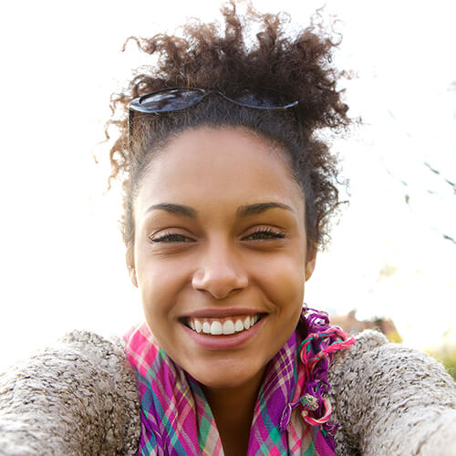 young-woman-smiling-and-talking-a-selfie-PPNZP4D.jpg